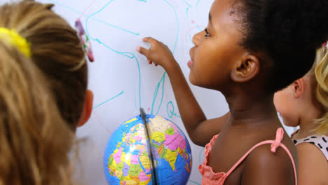 Kids-studying-globe-in-classroom