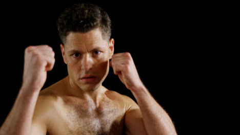 Portrait-of-man-boxing-on-black-background