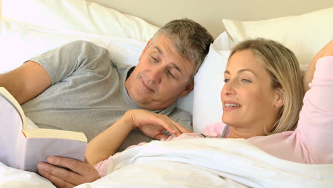 Couple-reading-a-book-in-bed