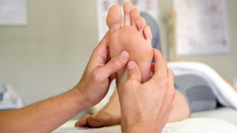 Physiotherapist-giving-foot-massage-to-a-woman