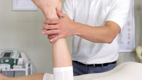 Male-physiotherapist-giving-leg-massage-to-female-patient
