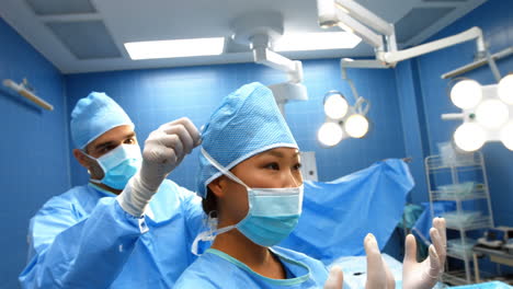 Surgeon-assisting-in-tying-surgical-mask