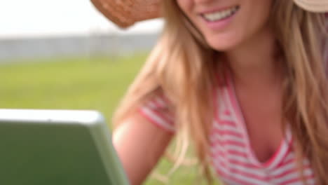 Mujer-Sonriente-Usando-Una-Computadora-Portátil-En-El-Parque-