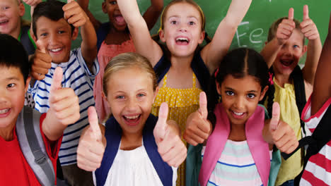 School-kids-showing-thumbs-up-in-classroom