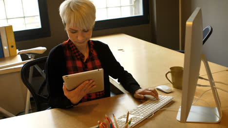 Weibliche-Führungskraft-Mit-Digitalem-Tablet-Und-Computer