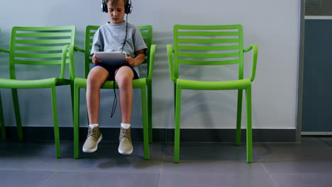 Boy-using-digital-tablet-in-hospital-corridor