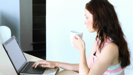 Mujer-Usando-Una-Computadora-Portátil-Y-Tomando-Café.-Sociedad-De-La-Comunicacion