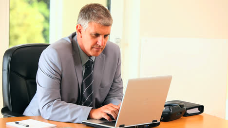 Middleaged-man-in-suit-working-on-a-laptop