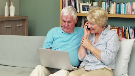 Senior-couple-using-laptop-and-smartphone