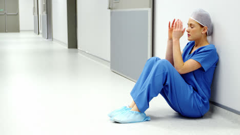 Besorgte-Krankenschwester-Sitzt-Auf-Dem-Boden