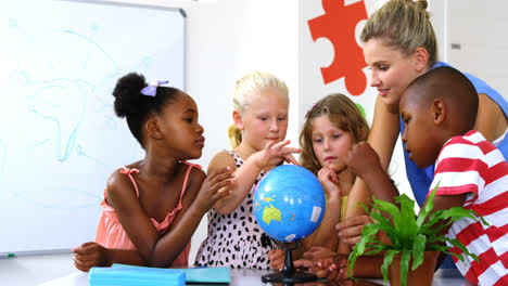 Teacher-discussing-globe-with-kids