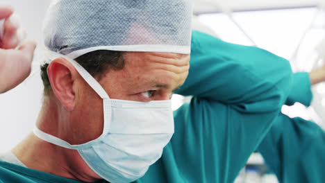 Surgeon-tying-surgical-mask