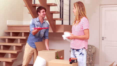Young-smiling-couple-unpacking-boxes
