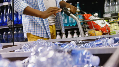Man-buying-bottle-of-water-at-grocery-section