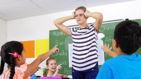 School-kids-throwing-paper-balls-on-teacher-in-classroom