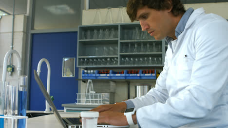 Scientist-checking-prescription-and-using-laptop