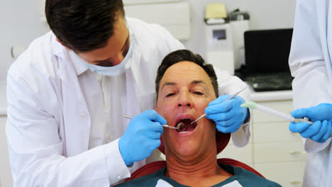 Dentistas-Examinando-A-Un-Paciente-Masculino-Con-Herramientas
