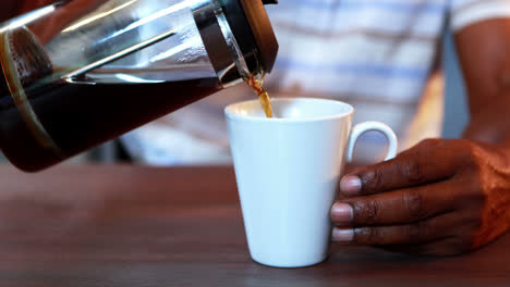 Senior-man-pouring-coffee-in-a-mug