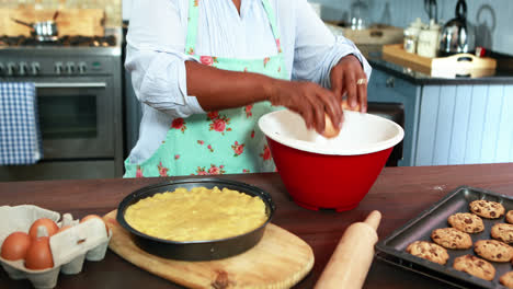 Senior-woman-breaking-egg-in-a-bowl