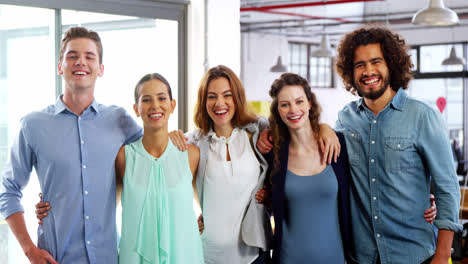 Portrait-of-a-happy-business-team-standing-with-arms-around