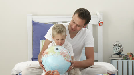 Father-and-son-looking-at-a-terrestrial-globe