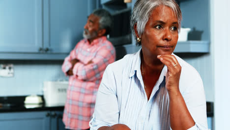 Senior-couple-ignoring-with-each-other-in-kitchen