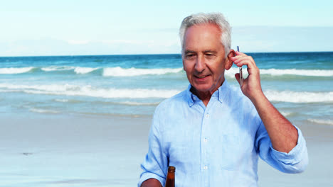 Senior-man-talking-on-mobile-phone-on-the-phone-at-the-beach