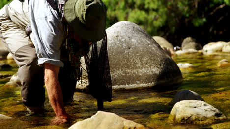 Fly-fisherman-searching-fish-in-shallow-river-water