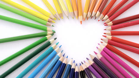 Lápices-De-Colores-Dispuestos-En-Forma-De-Corazón-Sobre-Fondo-Blanco.