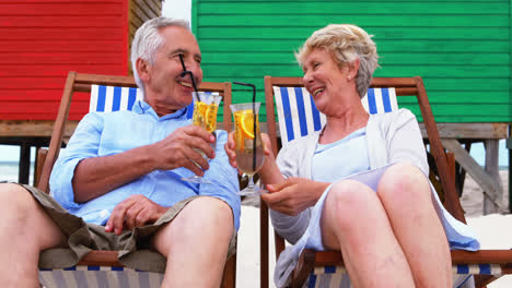 Senior-couple-enjoying-together-near-colorful-beach-hut