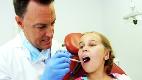 Dentist-examining-a-young-patient-with-a-tool