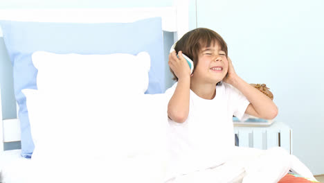 Little-boy-listening-to-music-on-his-bed