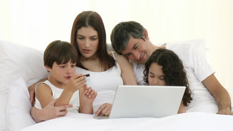 Eltern-Und-Kinder-Beim-Online-shopping-Im-Bett