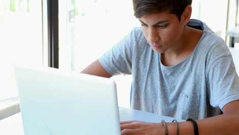 Schoolboy-using-laptop-in-classroom