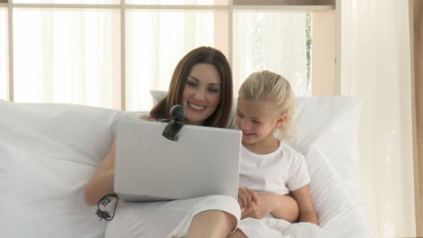 Beautiful-mother-and-daughter-having-a-conference-call-in-bed