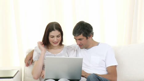 Couple-using-a-laptop-on-the-sofa