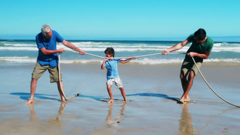 Family-playing-tug-of-war-at-the-beach