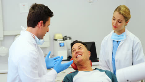 Dentistas-Interactuando-Con-Un-Paciente-Masculino