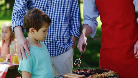 Multi-generation-family-preparing-food-on-barbecue