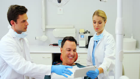 Dentists-showing-dental-report-on-digital-tablet