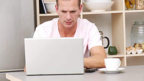 Man-working-with-a-laptop-in-kitchen