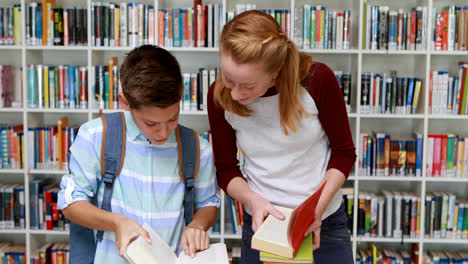 Smiling-students-reading-book-in-library