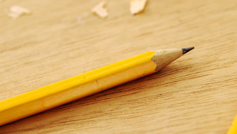 Broken-yellow-pencil-and-sharpener-on-wooden-background