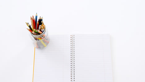Colored-pencils-kept-in-pencils-holder-kept-on-blank-paper