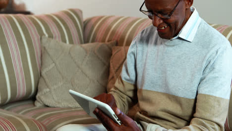Älterer-Mann-Nutzt-Digitales-Tablet-Im-Wohnzimmer