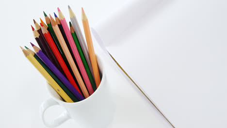 Colored-pencils-kept-in-mug-with-notepad