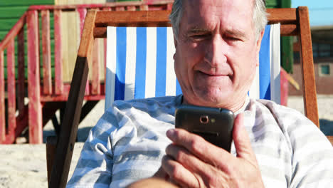 Älterer-Mann-Telefoniert-Mit-Dem-Handy,-Während-Er-Auf-Der-Sonnenliege-Entspannt