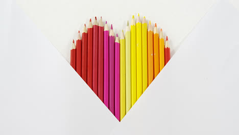 Lápices-De-Colores-Dispuestos-En-Forma-De-Corazón-Sobre-Fondo-Blanco.