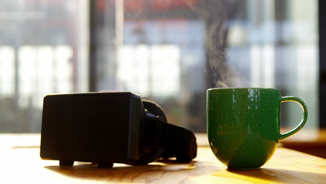 VR-Headset-Und-Tasse-Kaffee-Auf-Dem-Schreibtisch