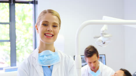 Portrait-of-smiling-dentist-standing-with-arms-crossed